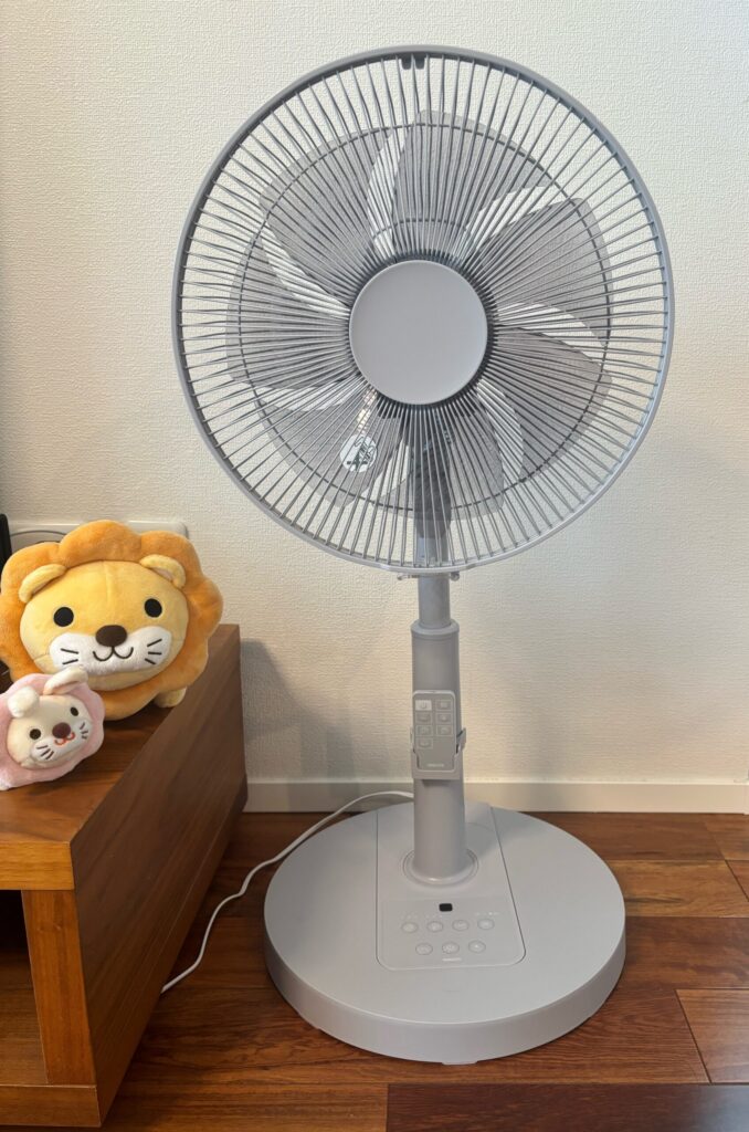 据え置き型のリビング扇風機と、横の棚に置かれたいるぬいぐるみの写真