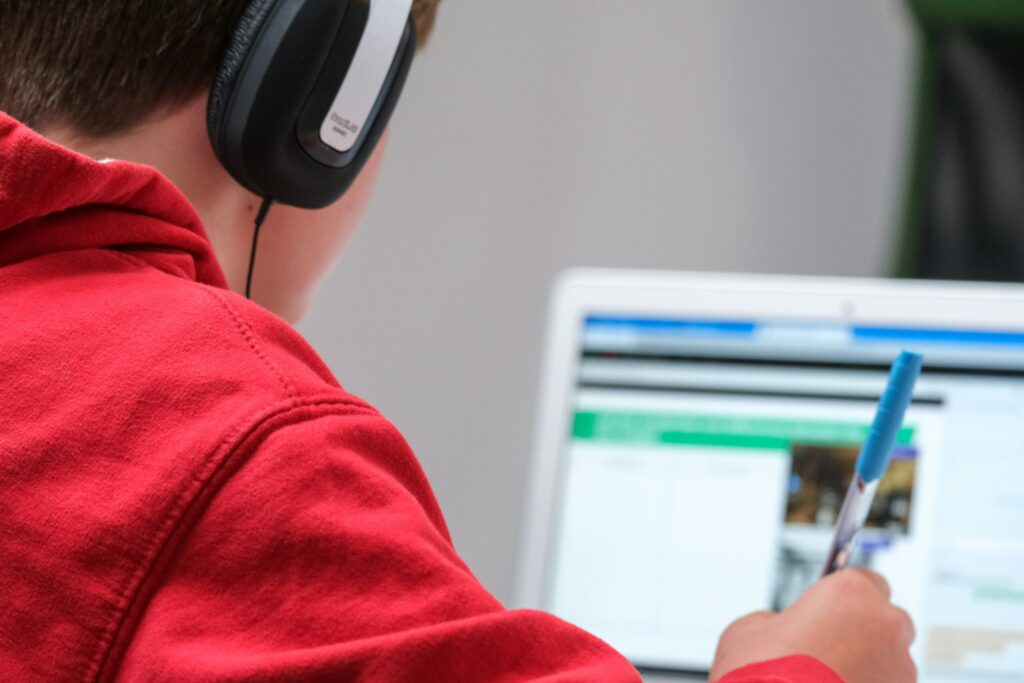 ヘッドホンをつけてオンライン学習する男の子のイメージ