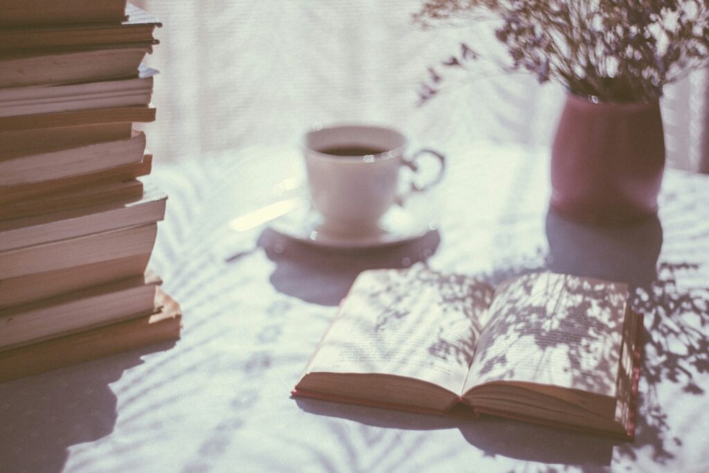 積まれた本とコーヒーと読みかけの本